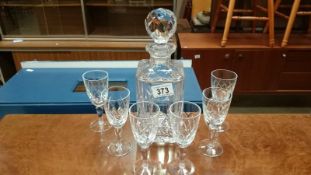 A cut glass decanter and 6 glasses