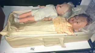 2 vintage dolls in carry cot
