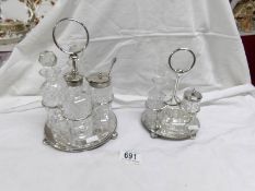 A 4 bottle glass condiment set on plated stand and one other