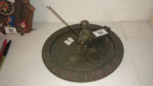 A metal sundial surmounted boy