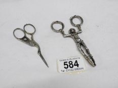 A pair of harlequin sugar nips and a pair of scissors shaped as a stork and marked Solingen Germany