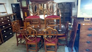 An extending mahogany dining table and 8 shield back chairs