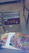 A box of classic rock LP records including Queen, Pink Floyd, Rolling Stones,