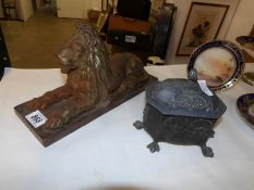 A metal casket and a cast iron lion