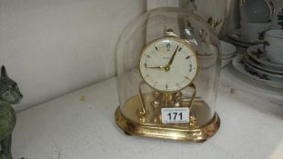 An anniversary clock under glass dome and with key