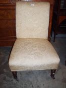 An Edwardian nursing chair with cream upholstery