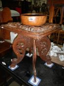 A carved side table and a wooden bowl