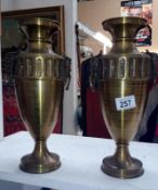 A pair of brass urns featuring Pan/Bacchus handles and stamped Bergica G F