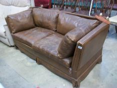 An old brown leather 'drop end' settee