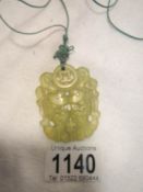 A light green jade pendant bound with a cord feng shui mystic knot