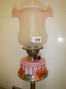 A Victorian brass column oil lamp with art nouveau decorated cranberry font and later shade