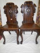 A pair of Victorian oak hall chairs