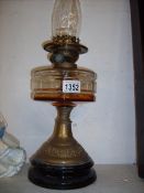 An oil lamp on pot base with brass column and glass font