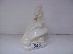 A Belleek figure of a leprechaun sitting on a toadstool