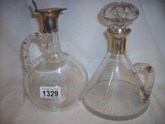 A glass decanter with silver top,