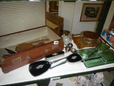 A vintage suitcase and vanity items including dressing table set,