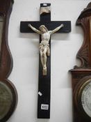 A large Crucifix with Christ in porcelain on an ebonised cross