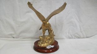 A brass eagle on wooden base