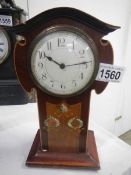An art nouveau mahogany clock with mother of pearl inlay