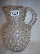 A Victorian glass water jug with pimple decoration