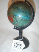 A miniature old tin globe on stand, approximately 3" diameter and 6.