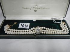 A cased 3 strand pearl choker with central stone set disc from the Duchess of Windsor collection