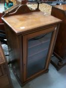 An Edwardian mahogany music cabinet with glazed door