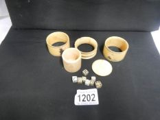 3 ivory napkin rings and an ivory dice pot with dice