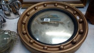 A circular convex mirror with bobble edged frame