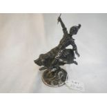 A heavy metal paperweight of boy riding pig