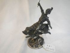 A heavy metal paperweight of boy riding pig