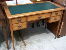 An Edwardian oak 5 drawer desk with green leather inset top