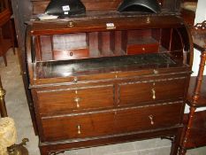 A 20th century barrel fronted bureau with fitted interior