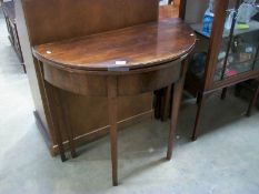 A Victorian mahogany fold over card/tea table on tapered legs