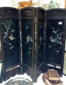 An Oriental black four fold screen inlaid with birds in mother of pearl