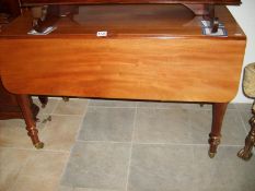 A mahogany Pembroke table on casters