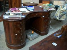 An inlaid mahogany kidney shaped double pedestal desk with burgundy leather top