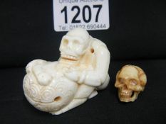 An ivory Okimono of a skeleton and a skull