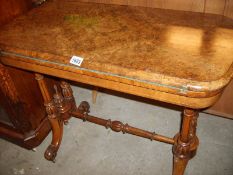 A Victorian figured walnut games table
