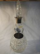 A cut glass decanter with silver collar,