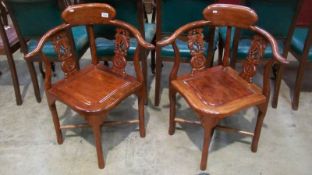 A pair of contemporary corner elbow chairs with Bachanalia cut rails