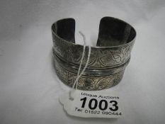 A middle eastern white metal slave calf bangle decorated with fishes and bearing 4 marks