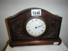 A carved oak mantel clock with French movement