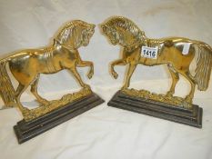 A pair of Victorian brass and iron horse door stops