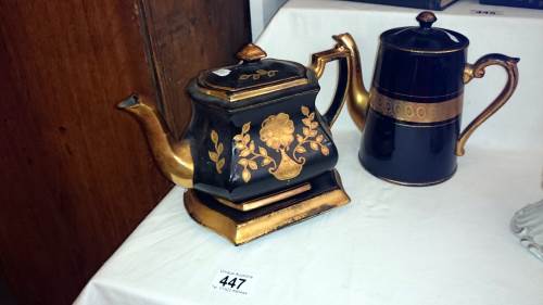 2 gold & black coloured teapots