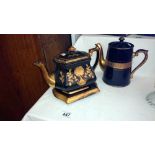 2 gold & black coloured teapots