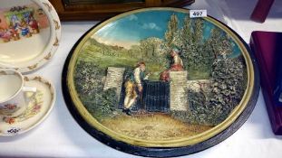 A wall plaque with a man & woman in garden