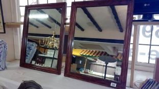 2 wooden framed mirrors