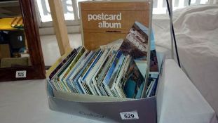 A quantity of postcards & a postcard album