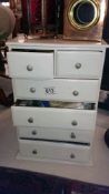 A very small 2 over 4 drawers containing sewing related items